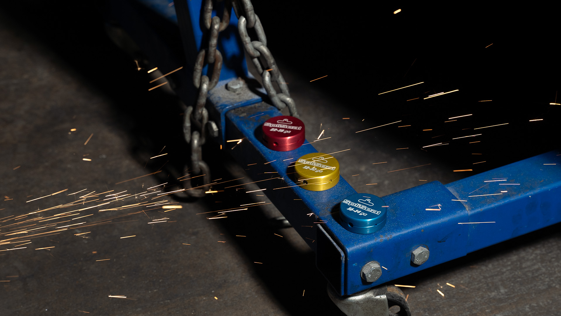 Red, gold and blue SpliSeal molds lined up on a trailer frame in the shop, sparks flying