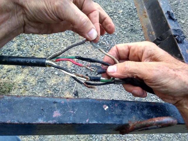 A frayed, damaged wiring harness with loose bare wires — a connection about to fail